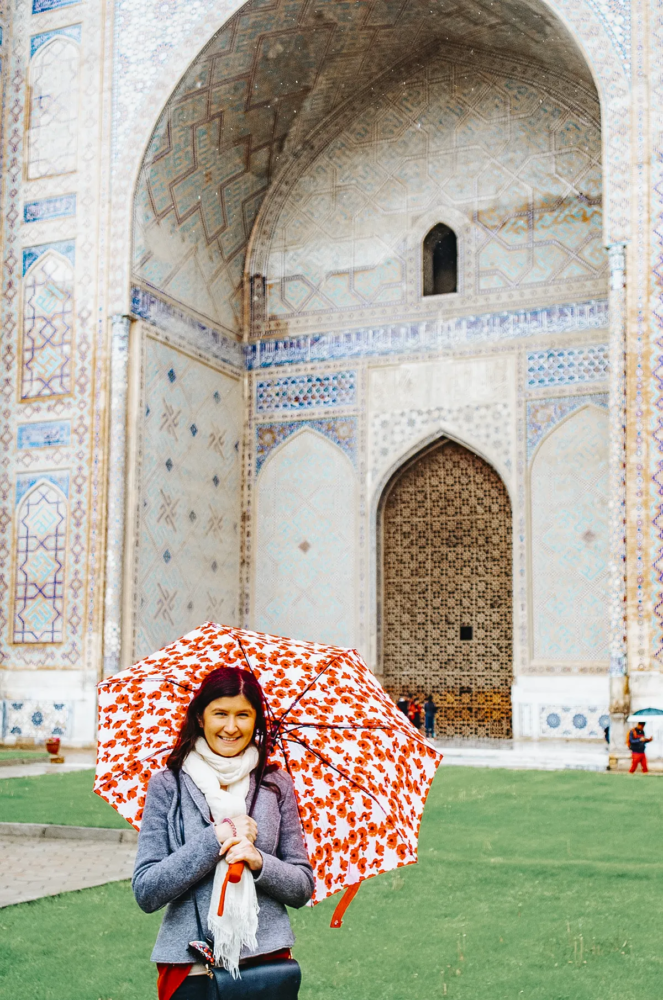 Woman with umbrella in front of Bibi-Khanym Mosque in Samarkand