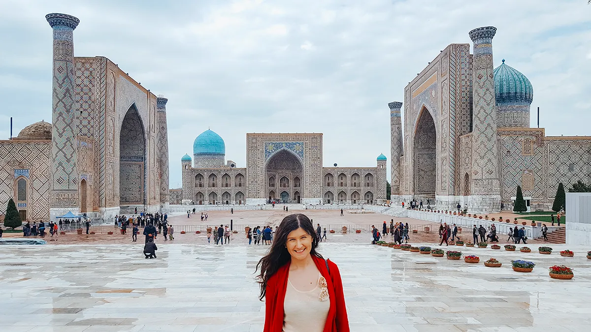 Traveler standing in Registan Square with three madrasas in the background in Samarkand