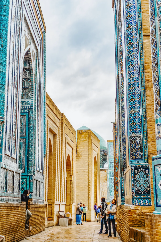Corridor at Shah-i-Zinda in Samarkand with blue tilework and visitors